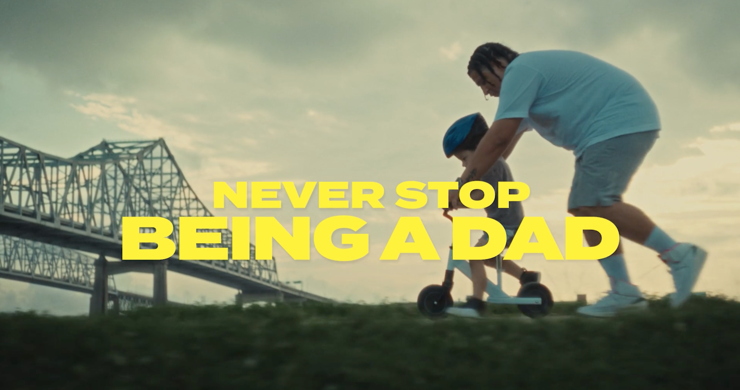 dad teaching son how to ride scooter with the caption never stop being a dad